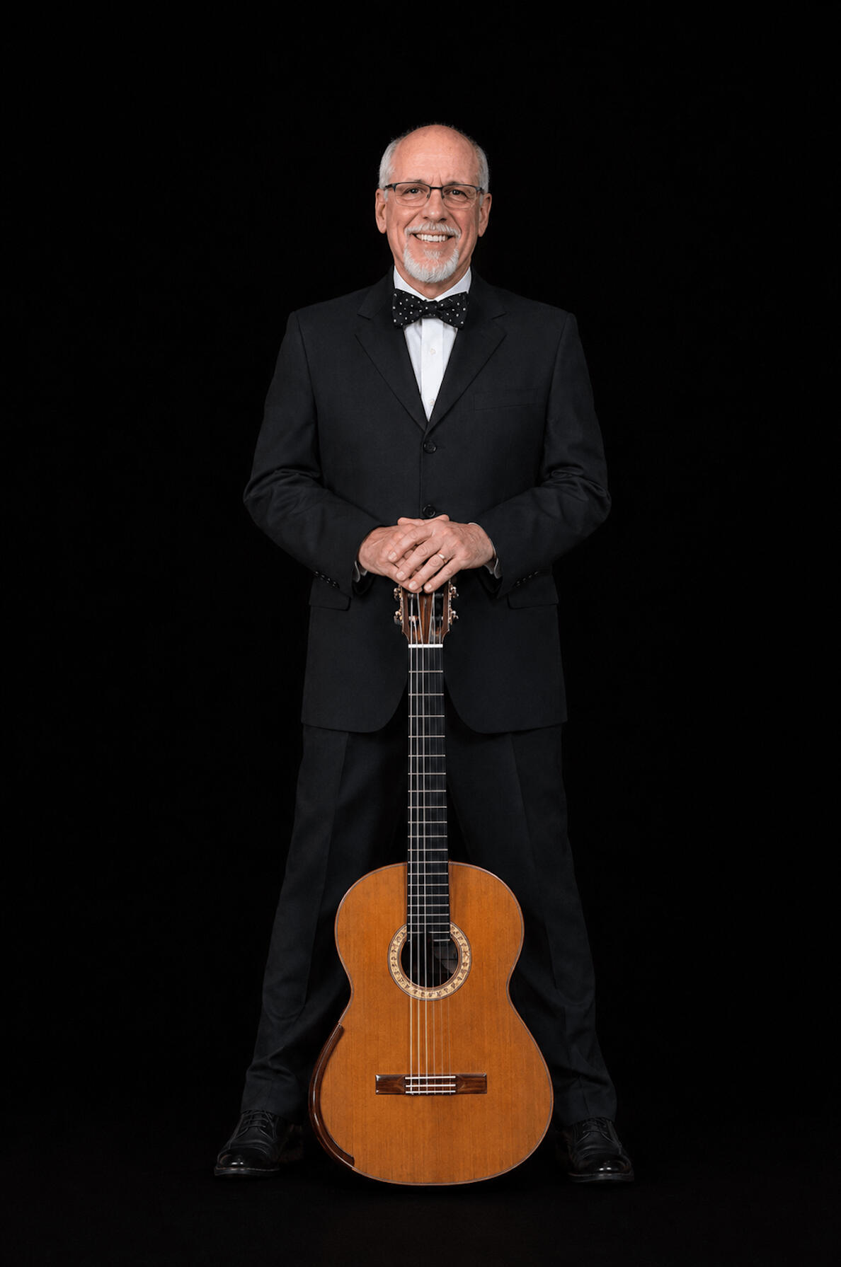 Miguel Bonachea, classical guitarist and performer Miguel Bonachea, a classical guitarist with white hair and beard, wearing glasses and formal concert attire standing and holding his guitar.